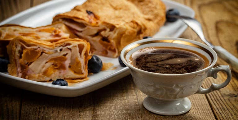 Apple strudel and a cup of coffee in a coffee house